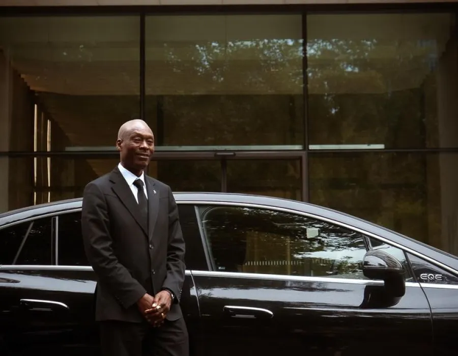 MIABA chauffeur standing by a black Mercedes